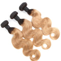 Three bundles of blonde and black hair extensions on a white background